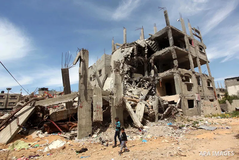 Palestinian children walk past the rubble of buildings that were destroyed during the 50-day Israeli war on Gaza Strip in the summer of 2014, in Gaza City's al-Shejaiya neighbourhood, on April 2, 2015. The Palestinians f...