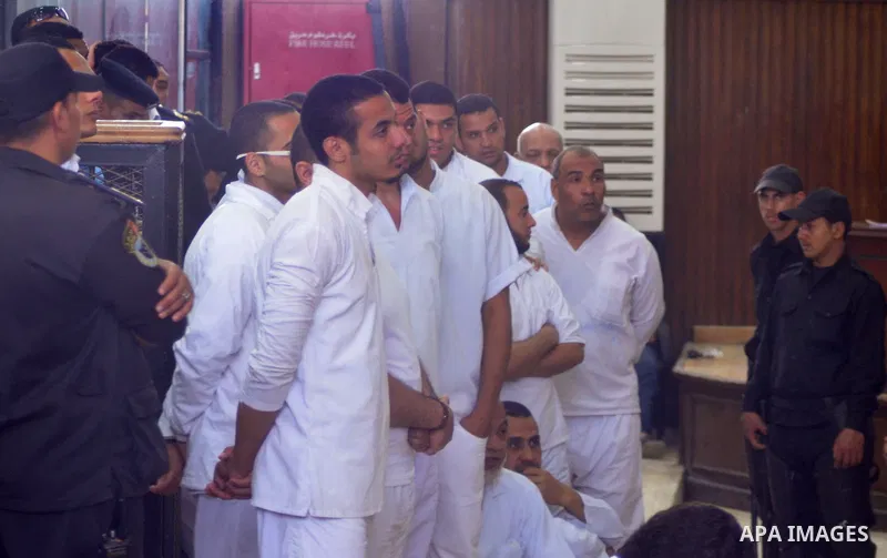 Egyptian defendants in the trial of US embassy violence stand in the court room during their trial in Cairo on April 2, 2015. The Cairo Criminal Court delayed the trial of 23 of members of Muslim Brotherhood accusing in...