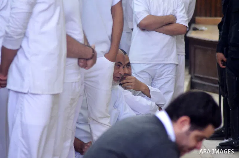 Egyptian defendants in the trial of US embassy violence stand in the court room during their trial in Cairo on April 2, 2015. The Cairo Criminal Court delayed the trial of 23 of members of Muslim Brotherhood accusing in...