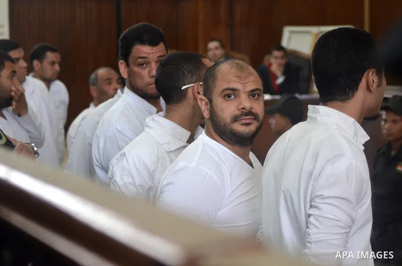 Egyptian defendants in the trial of US embassy violence stand in the court room during their trial in Cairo on April 2, 2015. The Cairo Criminal Court delayed the trial of 23 of members of Muslim Brotherhood accusing in...