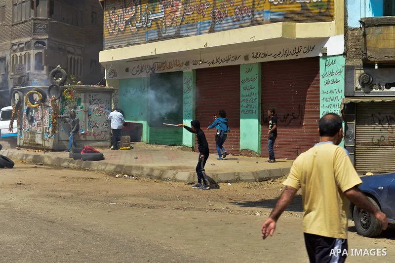 An Egyptian boy shots flares towards riot police during clashes with supporters of Muslim Brotherhood and ousted president Mohammed Morsi, in al-Matariya district near Cairo on April 3, 2015. Photo by Amr Sayed