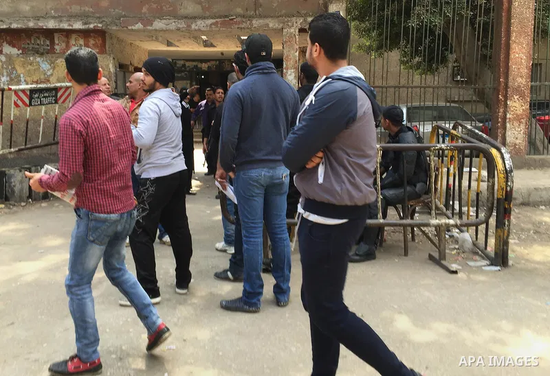 Egyptian investigators collect evidence at a bombing site where two homemade bombs exploded outside a public school in the Imbaba neighborhood of Giza, Egypt, Saturday, April 4, 2015. The two bombs planted outside the sc...