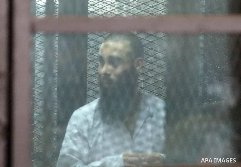 Members of Ansar Bayt al-Maqdis stand behind bars at a courtroom, during their trial in Cairo on April 4, 2015. 213 defendant members of Ansar al-Bayt al-Maqdis, including 140 defendants locked up, for committing a crime...