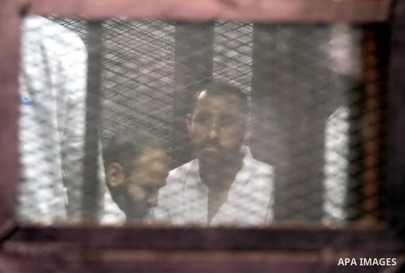 Members of Ansar Bayt al-Maqdis stand behind bars at a courtroom, during their trial in Cairo on April 4, 2015. 213 defendant members of Ansar al-Bayt al-Maqdis, including 140 defendants locked up, for committing a crime...