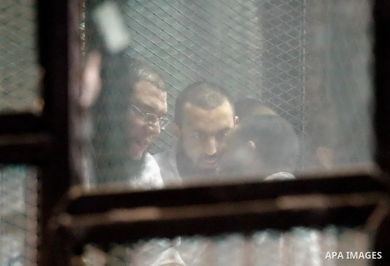 Members of Ansar Bayt al-Maqdis stand behind bars at a courtroom, during their trial in Cairo on April 4, 2015. 213 defendant members of Ansar al-Bayt al-Maqdis, including 140 defendants locked up, for committing a crime...