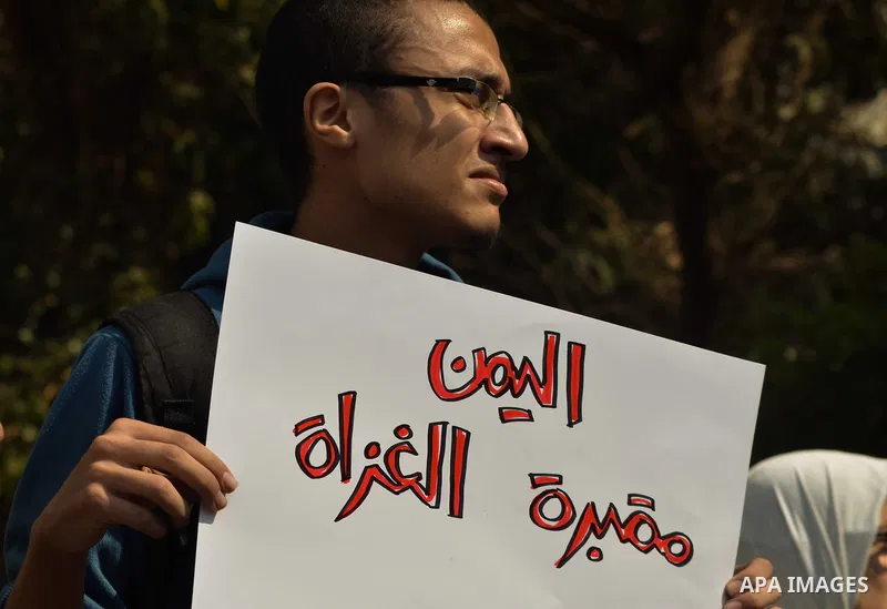 Egyptian protesters hold a placard during a demonstration against airstrikes carried out by the Saudi-led Arab coalition against Huthi militia in front of the Saudi Embassy, cairo, Egypt, on April 4, 2015. Photo by Amr S...