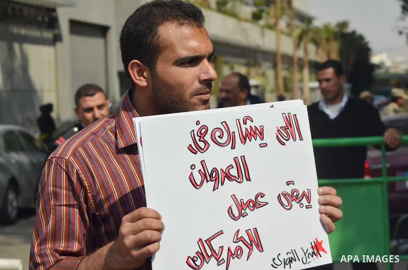 Egyptian protesters hold a placard during a demonstration against airstrikes carried out by the Saudi-led Arab coalition against Huthi militia in front of the Saudi Embassy, cairo, Egypt, on April 4, 2015. Photo by Amr S...