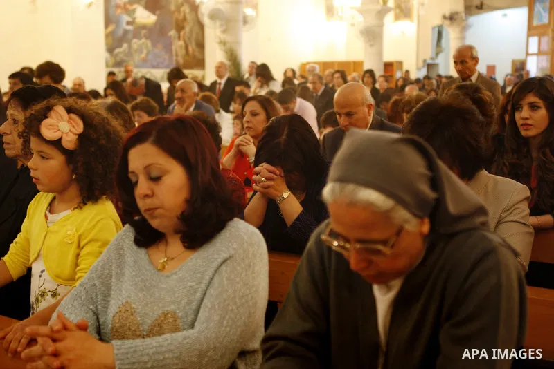 Palestinian Orthodox Christians attend the Palm Sunday mass at Latin Church in the West Bank city of Ramallah on April 5, 2015. Palm Sunday in many Christian churches symbolically marks the biblical account of the entry...