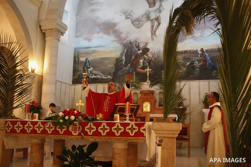 Palestinian Orthodox Christians attend the Palm Sunday mass at Latin Church in the West Bank city of Ramallah on April 5, 2015. Palm Sunday in many Christian churches symbolically marks the biblical account of the entry...