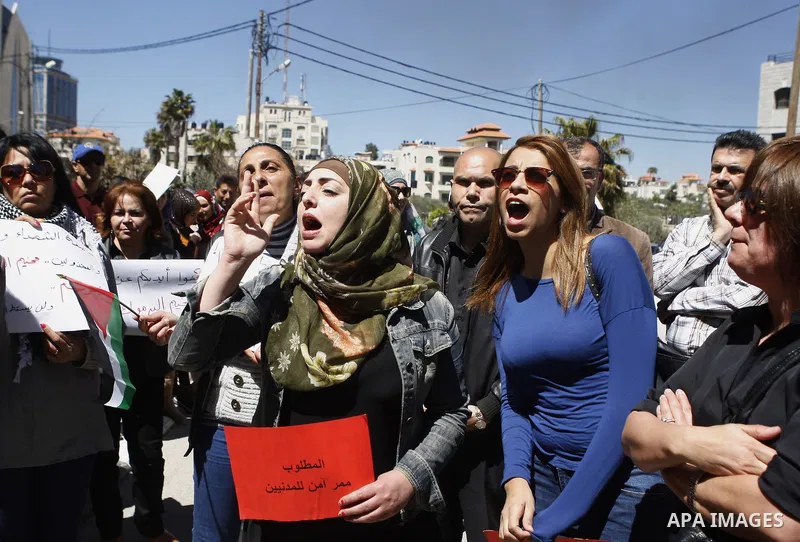 Palestinians hold banners during a protest to show solidarity with Palestinian refugees Syria's main refugee camp Yarmouk in the West Bank city of Ramallah, on April 05, 2015. Photo by Shadi Hatem