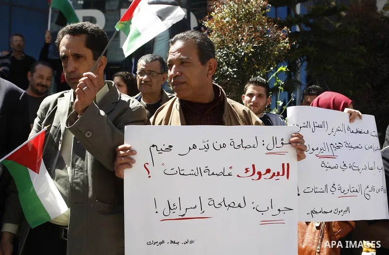 Palestinians hold banners during a protest to show solidarity with Palestinian refugees Syria's main refugee camp Yarmouk in the West Bank city of Ramallah, on April 05, 2015. Photo by Shadi Hatem