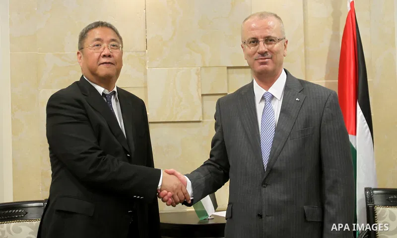 A handout picture released by the Prime Minister office show Palestinian Prime Minister Rami Hamdallah meeting with Chinese envoy for the Middle East Kong Xiao Sheng, in the West Bank city of Ramallah on April 5, 2015. P...