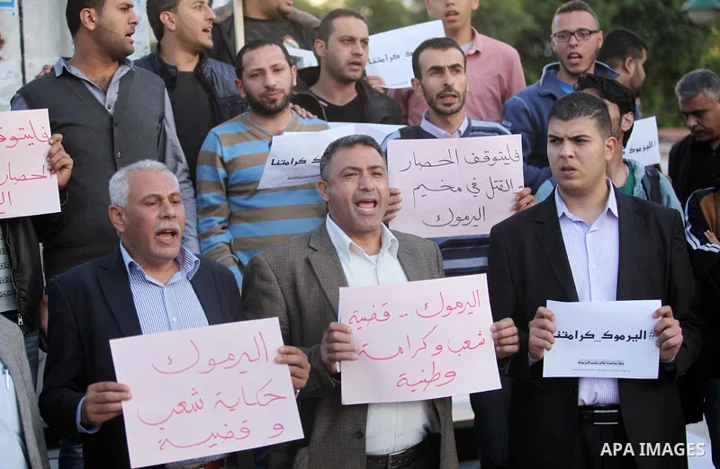 Palestinians shout slogans as they hold banners during a gathering in solidarity with the Palestinians living in Syria's Yarmouk camp, which is besieged by government forces and has been largely overrun by jihadist fight...