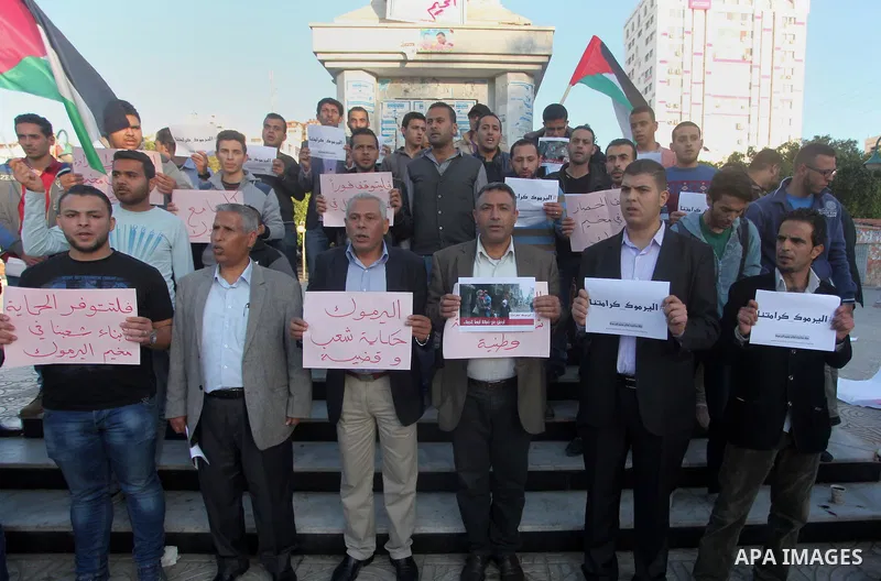 Palestinians shout slogans as they hold banners during a gathering in solidarity with the Palestinians living in Syria's Yarmouk camp, which is besieged by government forces and has been largely overrun by jihadist fight...