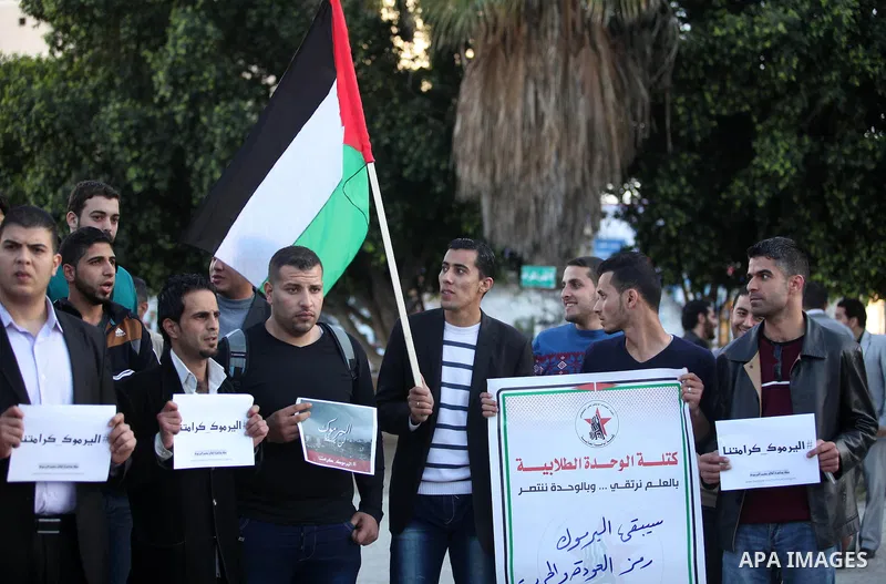 Palestinians shout slogans as they hold banners during a gathering in solidarity with the Palestinians living in Syria's Yarmouk camp, which is besieged by government forces and has been largely overrun by jihadist fight...