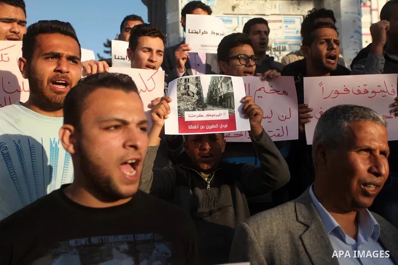 Palestinians shout slogans as they hold banners during a gathering in solidarity with the Palestinians living in Syria's Yarmouk camp, which is besieged by government forces and has been largely overrun by jihadist fight...