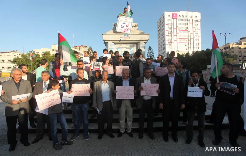 Palestinians shout slogans as they hold banners during a gathering in solidarity with the Palestinians living in Syria's Yarmouk camp, which is besieged by government forces and has been largely overrun by jihadist fight...