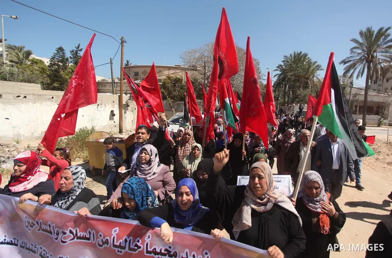 Palestinian supporters of the Democratic Front for the Liberation of Palestine (DFLP), shout slogans as they hold banners during a gathering in solidarity with the Palestinians living in Syria's Yarmouk camp, which is be...