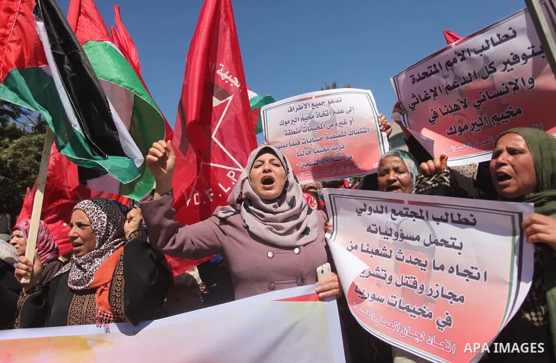 Palestinian supporters of the Democratic Front for the Liberation of Palestine (DFLP), shout slogans as they hold banners during a gathering in solidarity with the Palestinians living in Syria's Yarmouk camp, which is be...