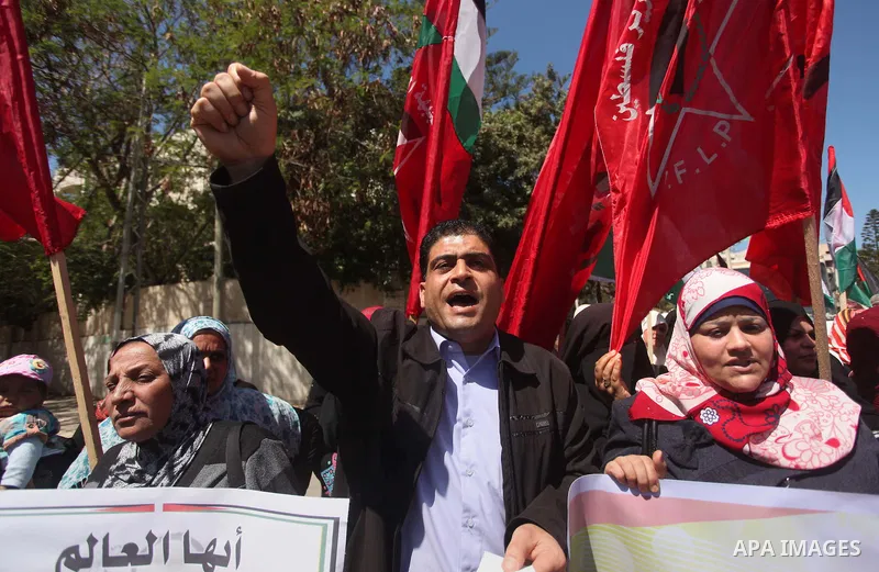 Palestinian supporters of the Democratic Front for the Liberation of Palestine (DFLP), shout slogans as they hold banners during a gathering in solidarity with the Palestinians living in Syria's Yarmouk camp, which is be...