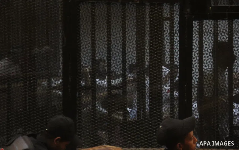 Egyptian defendants are seen behind bars during their trial of suspects in the 'Port Said Massacre' case in Cairo on April 6, 2015. The defendants were originally given sentences ranging from 15 years to life in prison....
