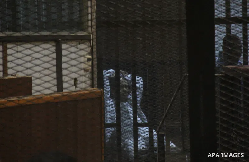Egyptian defendants are seen behind bars during their trial of suspects in the 'Port Said Massacre' case in Cairo on April 6, 2015. The defendants were originally given sentences ranging from 15 years to life in prison....