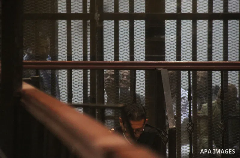 Egyptian defendants are seen behind bars during their trial of suspects in the 'Port Said Massacre' case in Cairo on April 6, 2015. The defendants were originally given sentences ranging from 15 years to life in prison....