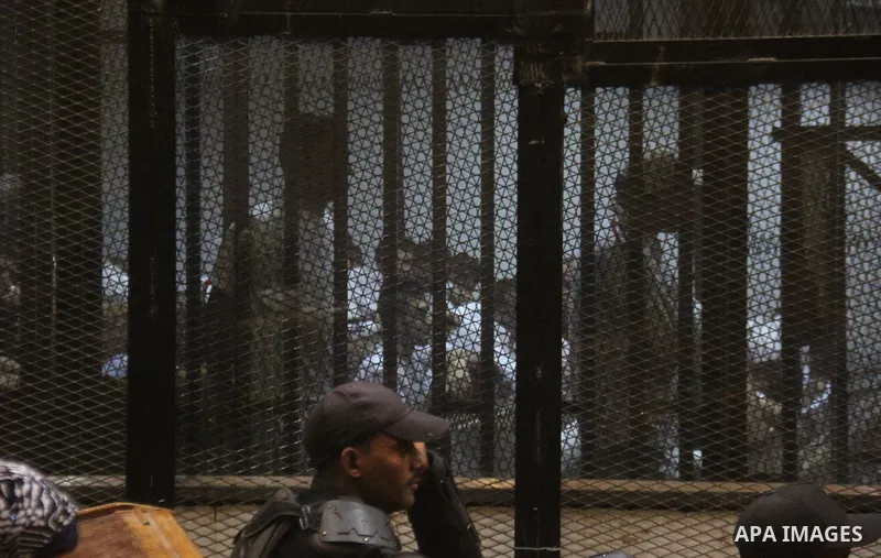 Egyptian defendants are seen behind bars during their trial of suspects in the 'Port Said Massacre' case in Cairo on April 6, 2015. The defendants were originally given sentences ranging from 15 years to life in prison....