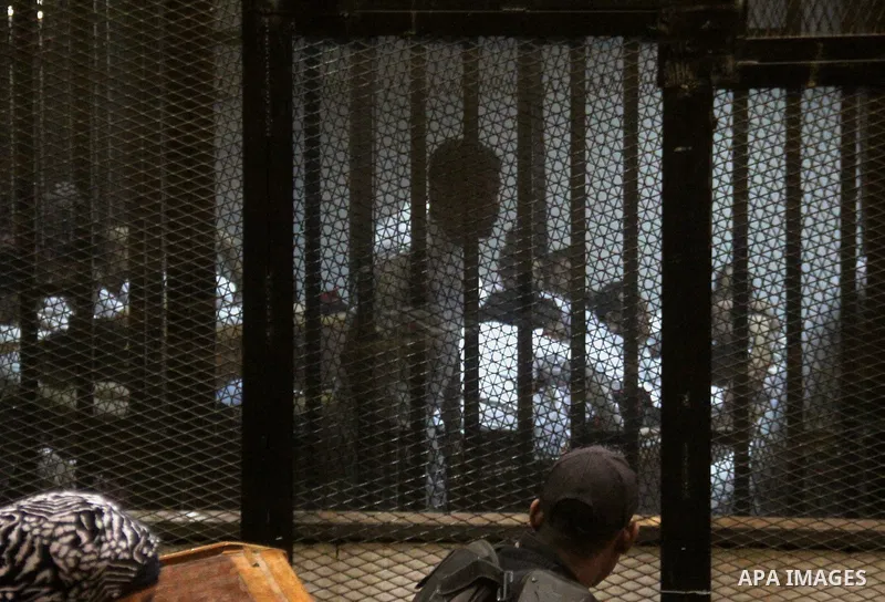 Egyptian defendants are seen behind bars during their trial of suspects in the 'Port Said Massacre' case in Cairo on April 6, 2015. The defendants were originally given sentences ranging from 15 years to life in prison....