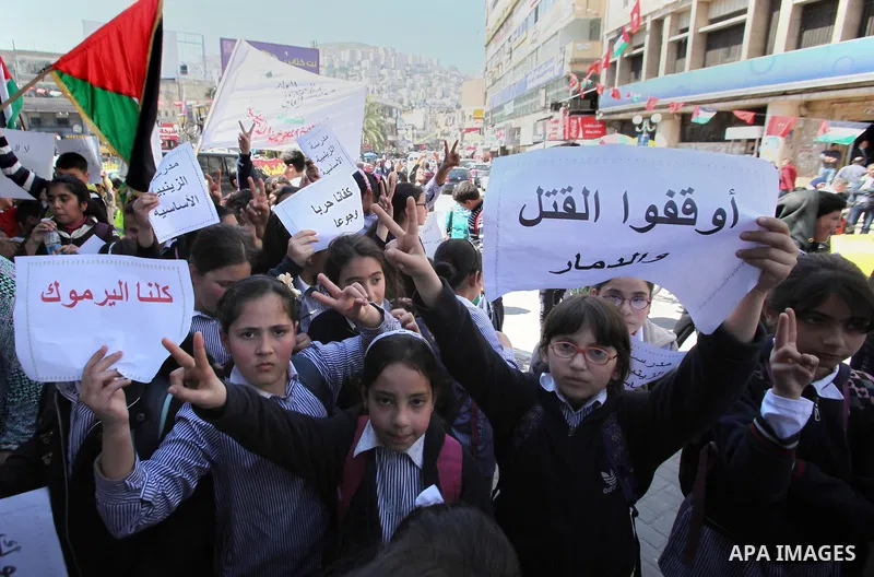 Palestinians take part a protest to show solidarity with the Palestinians living in Syria's Yarmouk camp, which is besieged by government forces and has been largely overrun by jihadist fighters, in the West bank city of...