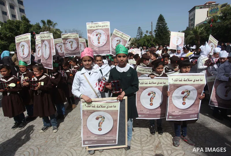 Palestinian students hold banners during a rally to mark the World Health Day, in Gaza city on April 7, 2015. Photo by Ashraf Amra