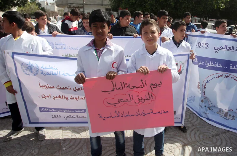 Palestinian students hold banners during a rally to mark the World Health Day, in Gaza city on April 7, 2015. Photo by Ashraf Amra