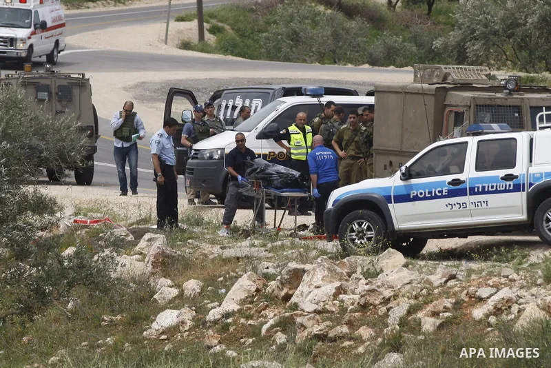 Israeli security forces and forensics surround the body of a Palestinian man, in the West Bank village of Sinjil, who was killed by Israeli forces after injuring two Israelis in a stabbing attack near the entrance to the...