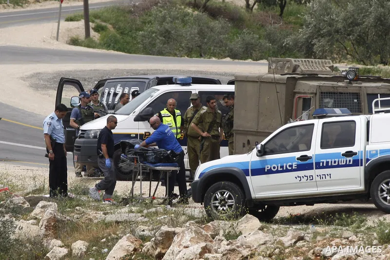 Israeli security forces and forensics surround the body of a Palestinian man, in the West Bank village of Sinjil, who was killed by Israeli forces after injuring two Israelis in a stabbing attack near the entrance to the...