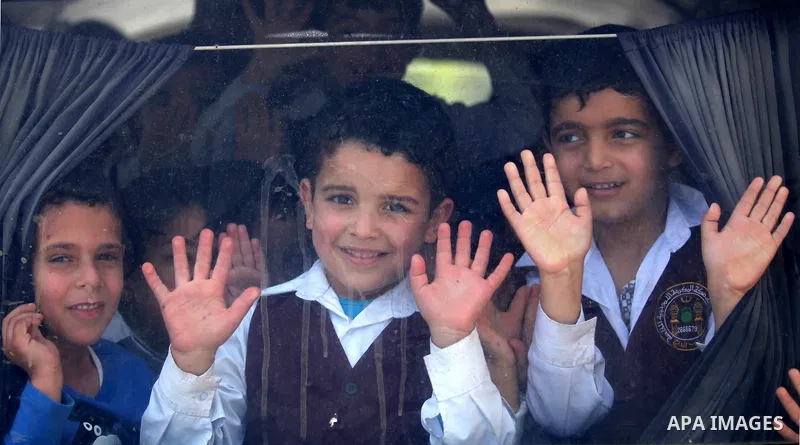 Kindergarten Palestinian children pose for a photograph as they ride their bus in Gaza city on April 8, 2015. Photo by Ashraf Amra