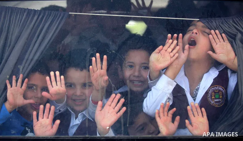 Kindergarten Palestinian children pose for a photograph as they ride their bus in Gaza city on April 8, 2015. Photo by Ashraf Amra
