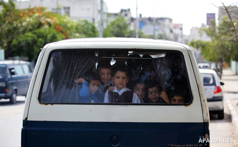 Kindergarten Palestinian children pose for a photograph as they ride their bus in Gaza city on April 8, 2015. Photo by Ashraf Amra