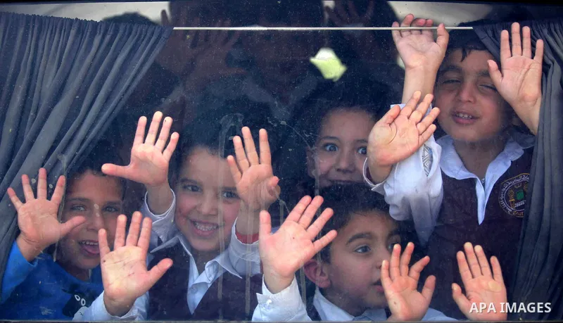 Kindergarten Palestinian children pose for a photograph as they ride their bus in Gaza city on April 8, 2015. Photo by Ashraf Amra