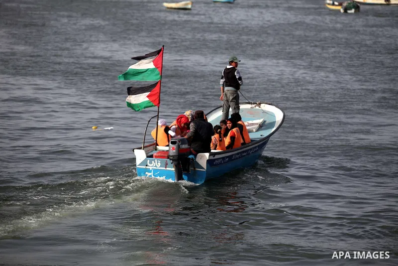 Palestinians ride boats in the Mediterranean Sea as they enjoy a warm day at the seaport in Gaza City on April 8, 2015. Photo by Ashraf Amra