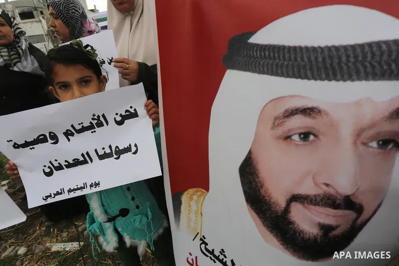 Relatives of Palestinian orphans hold banners during a protest against stop the payment of orphans aid in front of the rubbles of houses were destroyed during a seven-week Israeli offensive, in the east of Gaza City, on...