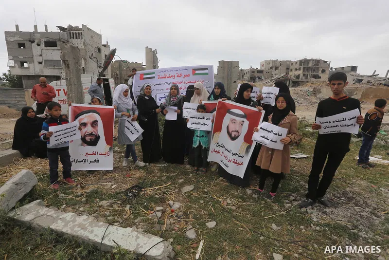 Relatives of Palestinian orphans hold banners during a protest against stop the payment of orphans aid in front of the rubbles of houses were destroyed during a seven-week Israeli offensive, in the east of Gaza City, on...
