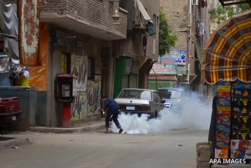 An Egyptian boy runs for cover from tear gas fired by riot police during clashes with supporters of Muslim Brotherhood and ousted president Mohammed Morsi following a protest against military rule in al-Matariya district...