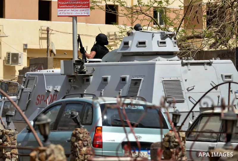 A member of Egyptian riot police stands on a military vehicle during clashes with supporters of Muslim Brotherhood and ousted president Mohammed Morsi following a protest against military rule in al-Matariya district, ne...