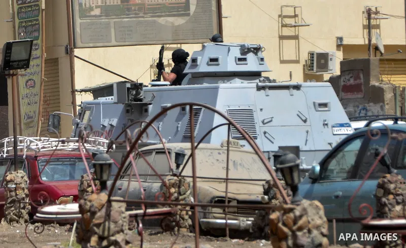A member of Egyptian riot police stands on a military vehicle during clashes with supporters of Muslim Brotherhood and ousted president Mohammed Morsi following a protest against military rule in al-Matariya district, ne...