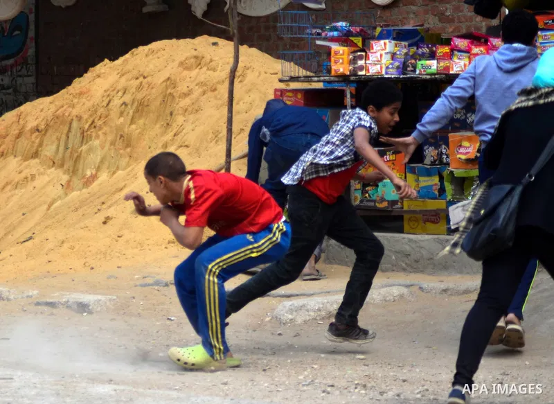 Supporters of Muslim Brotherhood and ousted president Mohammed Morsi throw stones at Egyptian riot police during clashes following a protest against military rule in al-Matariya district, near Cairo on April 10, 2015. Ph...
