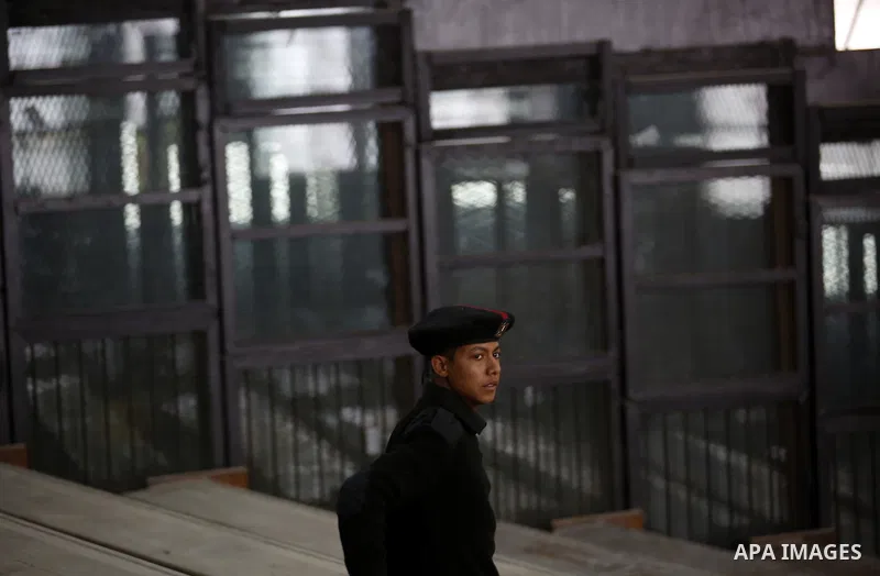 An Egyptian Policeman stands in front of empty bars during the trial of Muslim brotherhood leaders in Cairo, April 11, 2015. An Egyptian court sentenced Mohamed Badie, the leader of the outlawed Muslim Brotherhood, and 1...