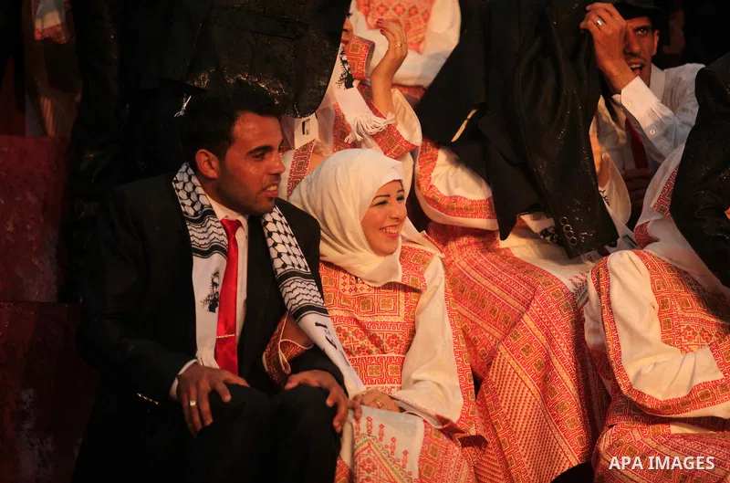 Palestinian brides and grooms leave the stage as the rain starts to fall during a mass stage wedding ceremony in Gaza City, on April 11, 2015. Nearly 200 Palestinian couples were married in a ceremony funded by an Emirat...