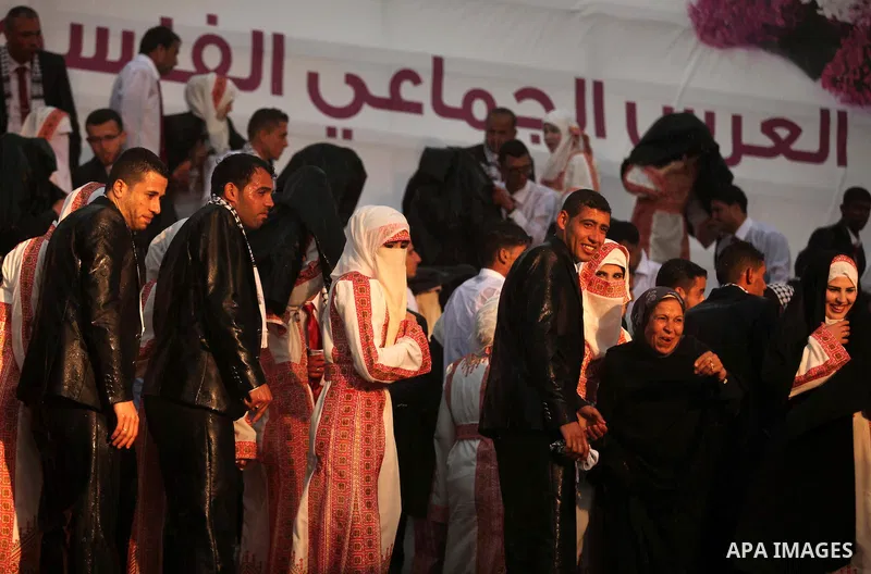 Palestinian brides and grooms leave the stage as the rain starts to fall during a mass stage wedding ceremony in Gaza City, on April 11, 2015. Nearly 200 Palestinian couples were married in a ceremony funded by an Emirat...