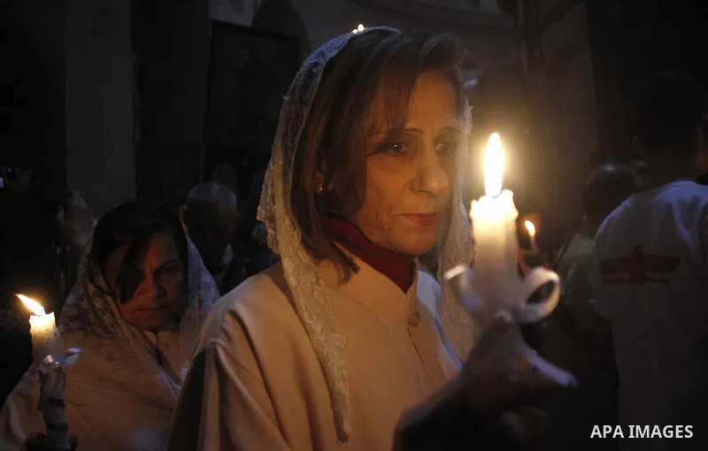 Christian Orthodox worshipers hold up candles lit from the "Holy Fire" as thousands gather in the Church of the Holy Sepulchre in Jerusalem's Old City, on April 11, 2015 during the Orthodox Easter ceremony of the "Holy F...