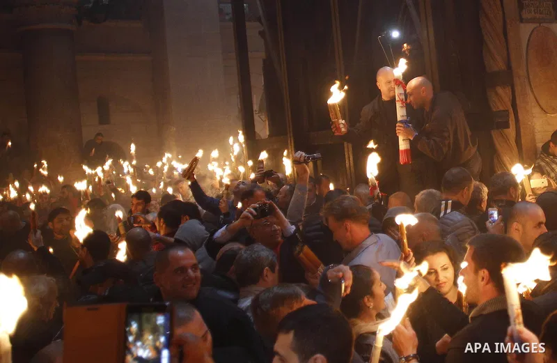 Christian Orthodox worshipers hold up candles lit from the "Holy Fire" as thousands gather in the Church of the Holy Sepulchre in Jerusalem's Old City, on April 11, 2015 during the Orthodox Easter ceremony of the "Holy F...